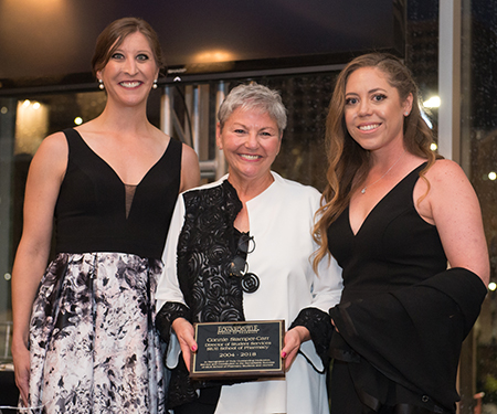 SIUE School of Pharmacy alumnae Maggie Krumwiede (left) and Kelly Kleeman (right) presented a plaque “in recognition of truly outstanding dedication” to retiring director of Student Services Connie Stamper-Carr.